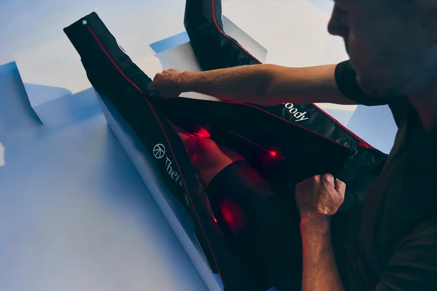 Man using Therabody Jetboots pro plus with infrared light 